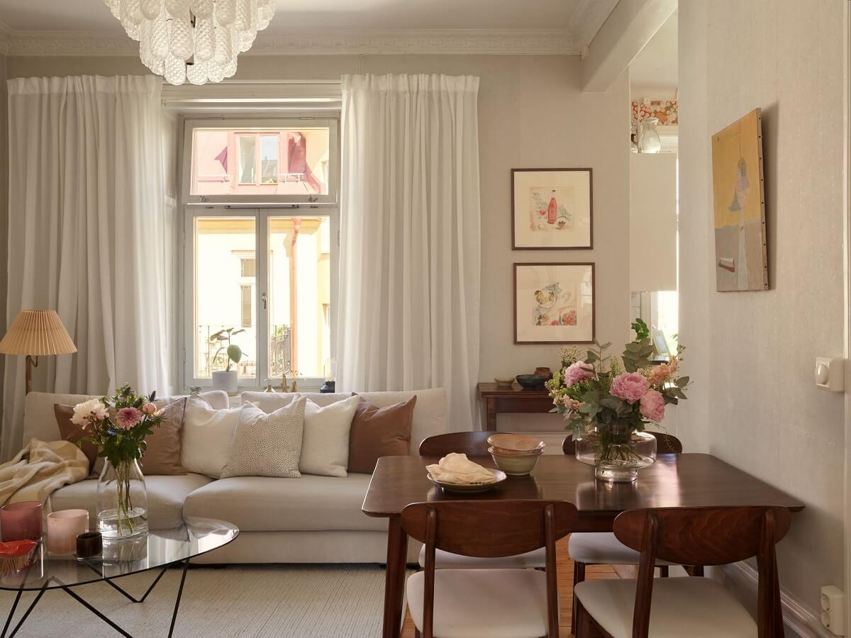 Características de época e cores claras em um apartamento de um quarto 4 sala de estar clara com mesa de madeira