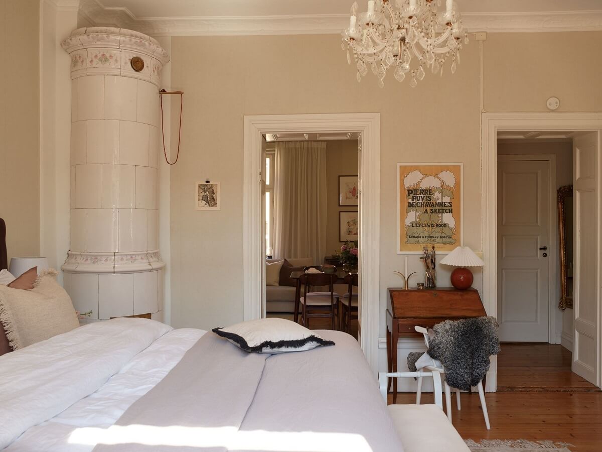 Características de época e cores claras em um apartamento de um quarto 16 quarto bege com piso de madeira e lareira. Características da época e cores claras em um apartamento de um quarto