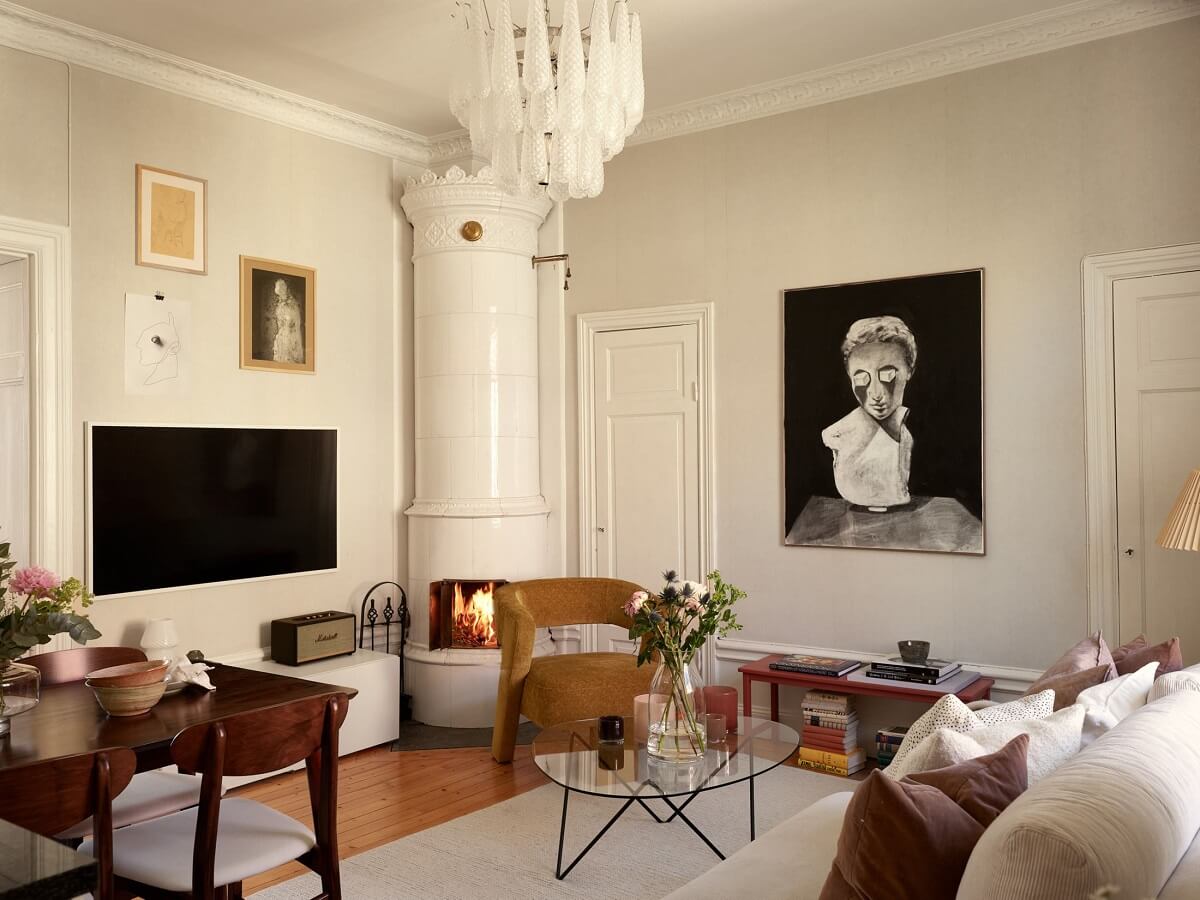 Características de época e cores claras em um apartamento de um quarto 1 aconchegante sala de estar com cadeira amarela ocre e lareira
